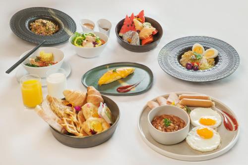 een tafel met borden en kommen eten bij Royal Phuket City Hotel in Phuket