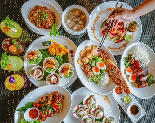 een tafel vol borden eten op een tafel bij Royal Phuket City Hotel in Phuket