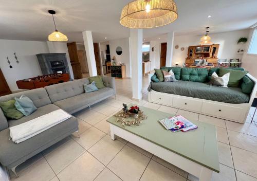 a living room with two couches and a table at L'abreuvoir de la Mer- villa - plage in Sangatte