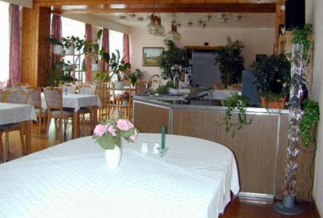 ein Restaurant mit einem Tisch mit einer Blumenvase darauf in der Unterkunft Hotel Zur Rose in Trebbin