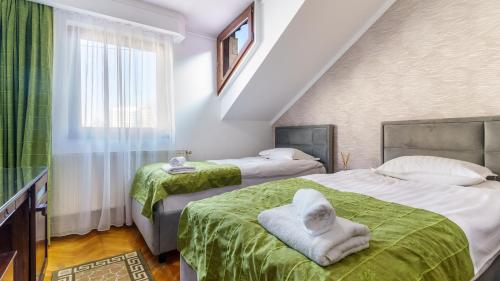 een slaapkamer met twee bedden met handdoeken erop bij Pension Arena in Cluj-Napoca