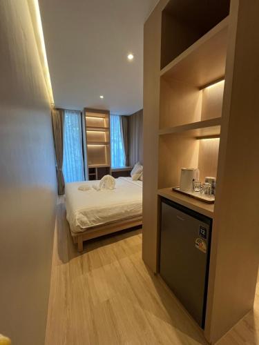 a small room with a bed and a laptop on a counter at The Warehouse Chiang Mai in Chiang Mai