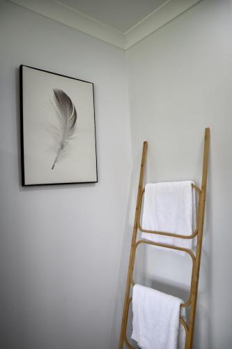 a picture of a feather on a wall next to a ladder at Two Williams Estate - Hunter Valley in Cessnock