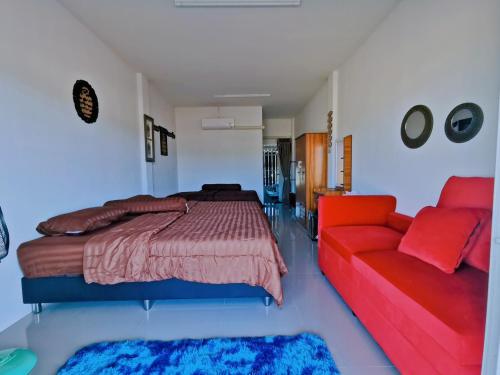 une chambre avec un lit et un canapé dans l'établissement บ้านพักคุณอร, à Ban Ku Sua