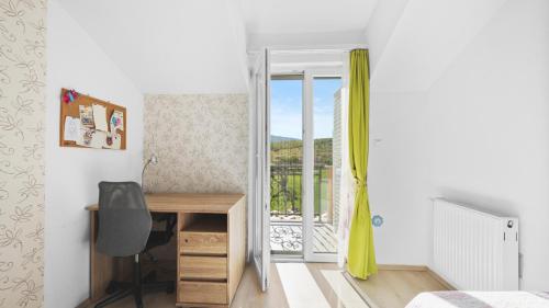 een slaapkamer met een bureau en een balkon bij Villa Pleter by Villas Guide in Otavice
