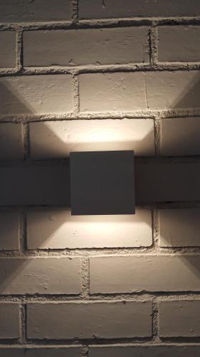 a light on the side of a brick wall at Alma Hotel in Palermo
