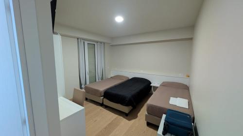 een kleine kamer met twee bedden en een spiegel bij L'Ulivo in Almè