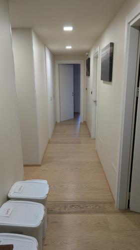 a hallway with white walls and a row of stools at L'Ulivo in Almè