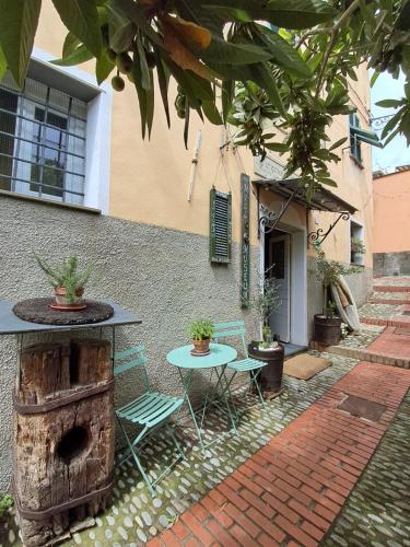 een terras met een tafel en stoelen naast een gebouw bij Gumbo del Metre in Cervo