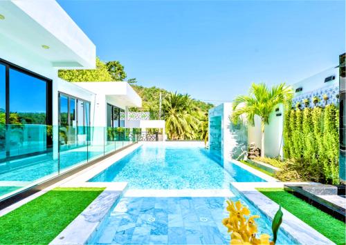 a swimming pool in the backyard of a house at Zen-Inspired Villa Retreat, Resort-Style Pool, Stunning Rooftop & Kid-Friendly Playground in Rawai Beach