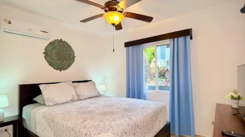 een slaapkamer met een bed, een plafondventilator en een raam bij Sunny dream in Sandy Bay