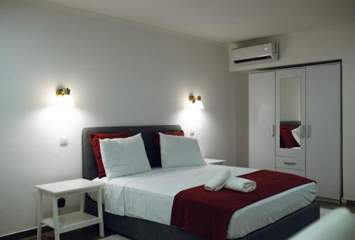 a bedroom with a large bed with a red blanket at Onzo Yamy in Luanda
