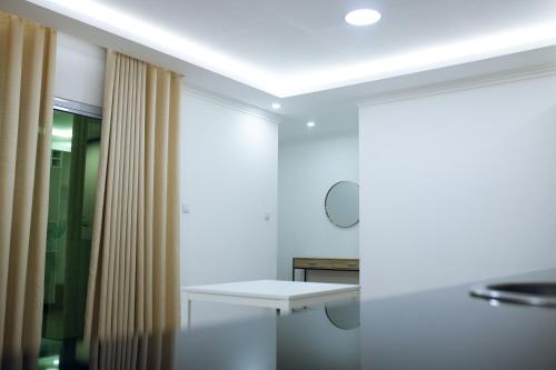 a white room with a table and a mirror at Onzo Yamy in Luanda