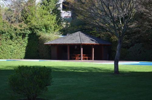 a gazebo in the middle of a green field at Departamento Pucon in Pucón