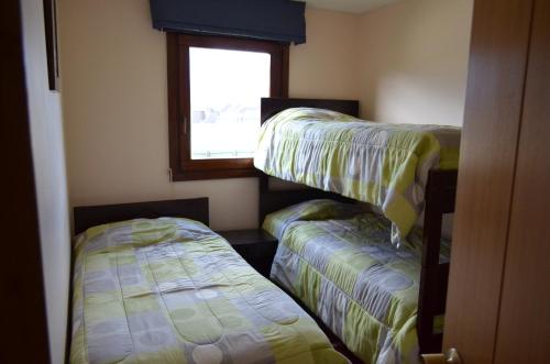 two bunk beds in a room with a window at Departamento Pucon in Pucón