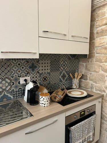 una cucina con mobili bianchi e un piano di lavoro di Il Corallo a Molfetta