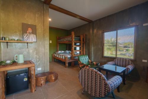 un soggiorno con un letto, un tavolo e delle sedie di Bricks & Bed house pai a Ban Wiang Nua