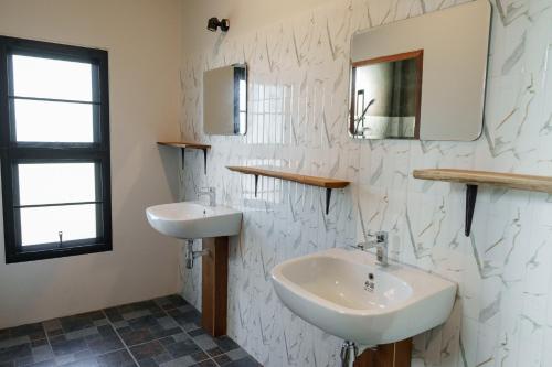 un bagno bianco con lavandino e specchio di Bricks & Bed house pai a Ban Wiang Nua