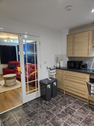 a kitchen with a counter and a room with a couch at Duxford Haven in Duxford