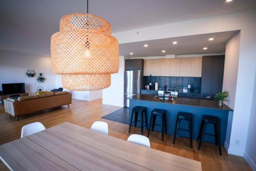 een keuken en woonkamer met een tafel en stoelen bij 309 - Luxury Condo - Spectacular View & Pool in Baie-Saint-Paul