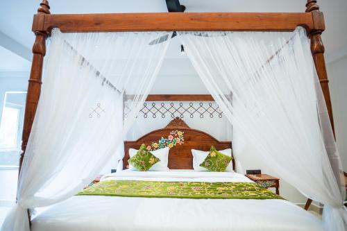 a bedroom with a canopy bed with white curtains at Hotel Indiana Hitech City in Hyderabad