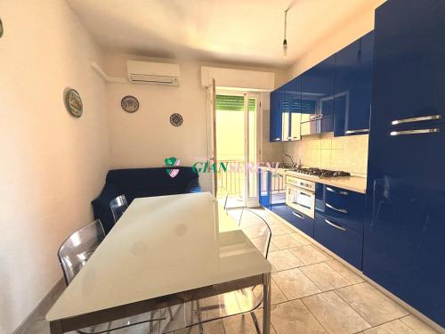 eine Küche mit blauen Schränken sowie einem Tisch und Stühlen in der Unterkunft Nettuno in Rom