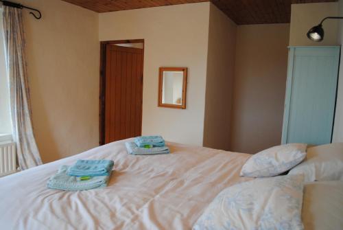 two towels are sitting on top of a bed at The Castle Bed & Breakfast in Ballintoy