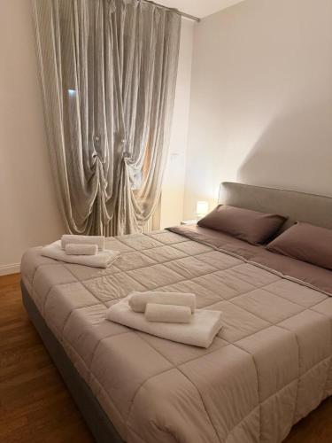 a bedroom with a large bed with two towels on it at Rose e Frutta - Silver Moon in Monfalcone