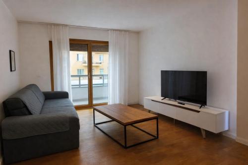 een woonkamer met een bank en een flatscreen-tv bij Rose e Frutta - Silver Moon in Monfalcone