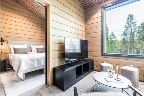 una camera da letto con un letto, una televisione e un tavolo di Levin Lyhty Dawn D4 by Hilla Villas a Kittilä