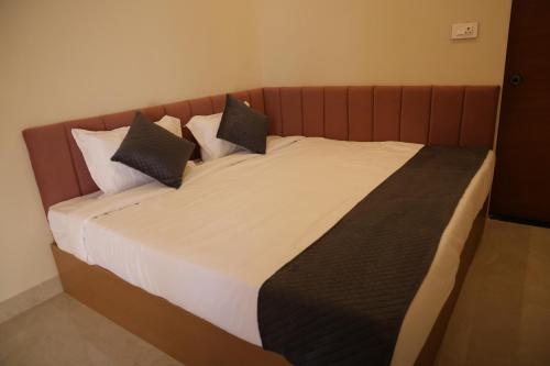 a bed with three pillows on it in a room at The Rukmani villas in Jāmb