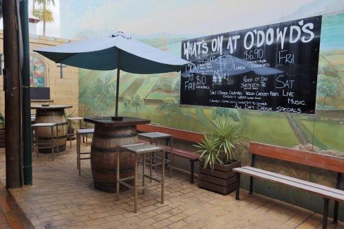 
an outdoor cafe with tables and umbrellas at O'Dowds Hotel/Motel Rockhampton in Rockhampton
