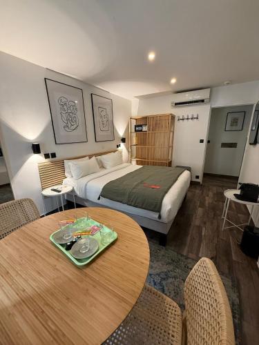 ein Hotelzimmer mit einem Bett und einem Tisch in der Unterkunft Hotel de Berne in Nizza