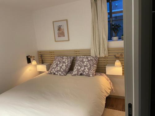 a bedroom with a bed with two pillows and a window at Les Rives du vignoble in Ingersheim
