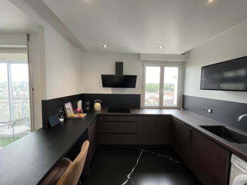 a kitchen with a black counter and a sink at Atypaluxe Appartement 3 chambres in Épinal