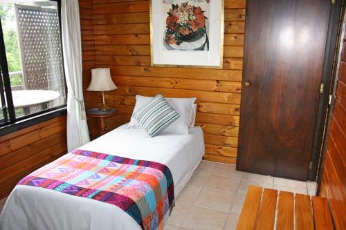 1 dormitorio con cama y ventana en Lavendula Garden Cottage, en Burnt Pine