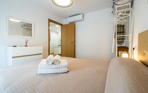 a bedroom with a bed with towels on it at YourHouse Apartamentos Andasol 1D in Chipiona