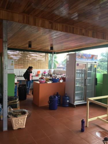 a woman standing in a kitchen with a counter in a room at Vongprachan Backpackers Hostel in Luang Prabang