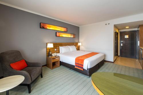 een hotelkamer met een bed en een stoel bij Maple Hotel in Bangkok