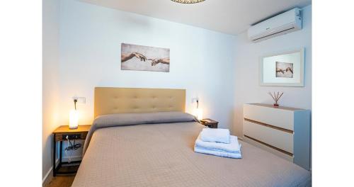 a bedroom with a bed and a desk with two lamps at YourHouse Apartamentos Andasol 1 I in Chipiona