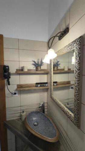 a bathroom with a sink and a mirror at Pozar Park Rooms in Orma