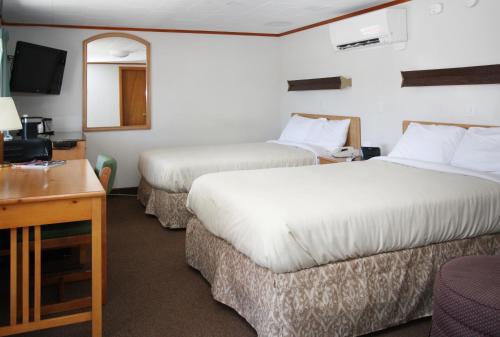 um quarto de hotel com duas camas e uma secretária em The Bluebird Motel Maine em Machias
