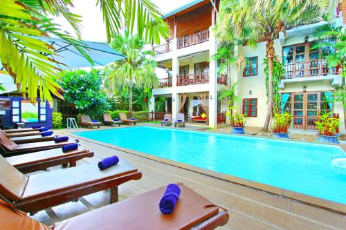 a hotel with a swimming pool and lounge chairs at Shewe Wana Boutique Hotel in Chiang Mai