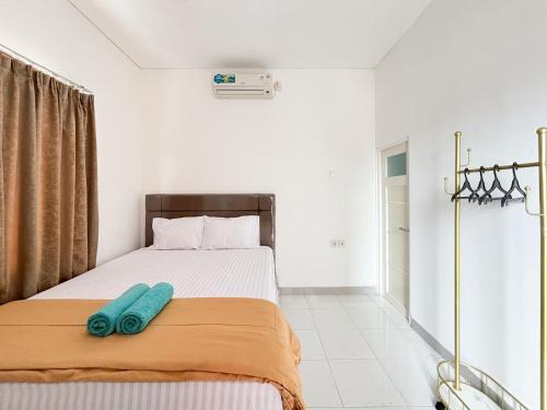 una camera da letto con un letto con due cuscini blu sopra di Sofia Residence Syariah Mitra RedDoorz a Malang
