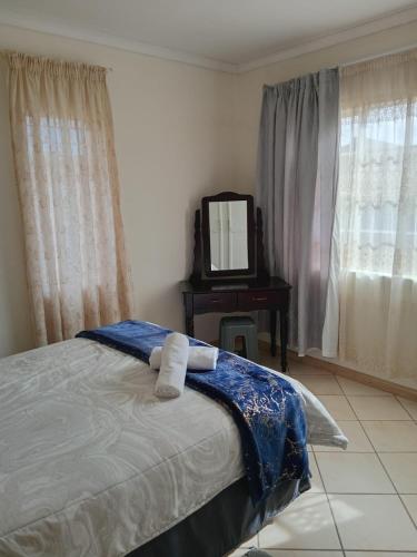 a bedroom with a bed with a mirror and a vanity at VSA SELF CATERING unit 1 in Newcastle