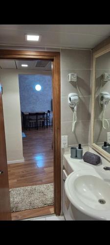 uma casa de banho com um lavatório, um espelho e uma mesa em יולי גולף em Cesareia