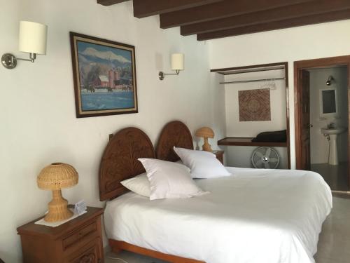 1 dormitorio con 2 camas y mesa con lámpara en Posada del Virrey, en Tequisquiapan