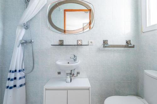 een badkamer met een wastafel en een spiegel en een toilet bij Studio Clim proche plage et parking in Carqueiranne