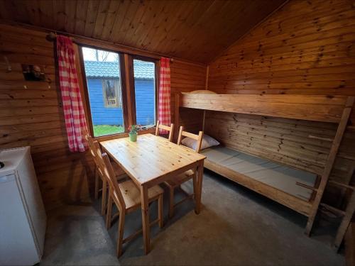 een houten kamer met een tafel en een stapelbed bij Camping Suderse - It Sweltsje in Workum