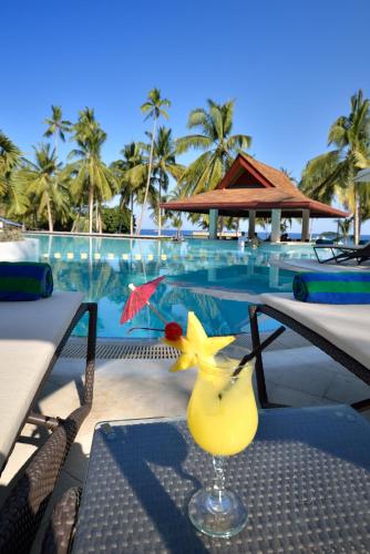 a drink sitting on a table next to a pool at Henann Resort Alona Beach in Panglao